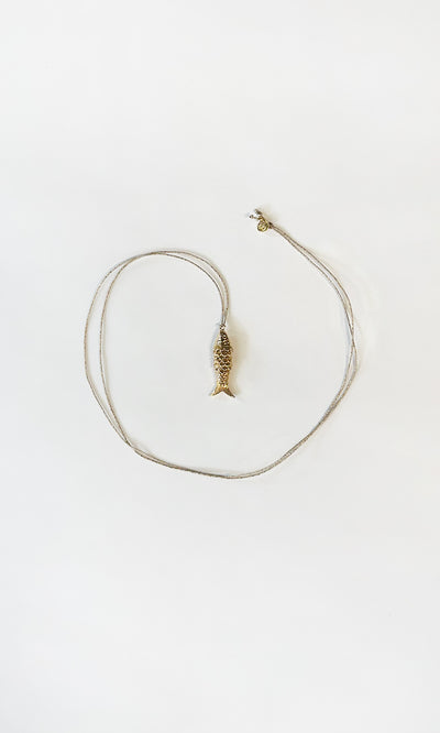 Plümo  The Celine Necklace is a gold-plated fish pendant, heart-shaped and adjustable—perfect for layering.