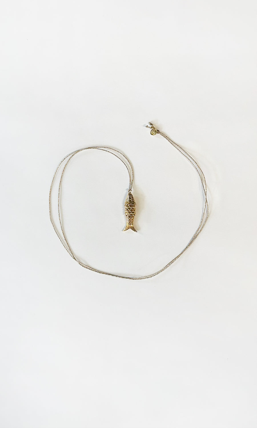 Plümo  The Celine Necklace is a gold-plated fish pendant, heart-shaped and adjustable—perfect for layering.