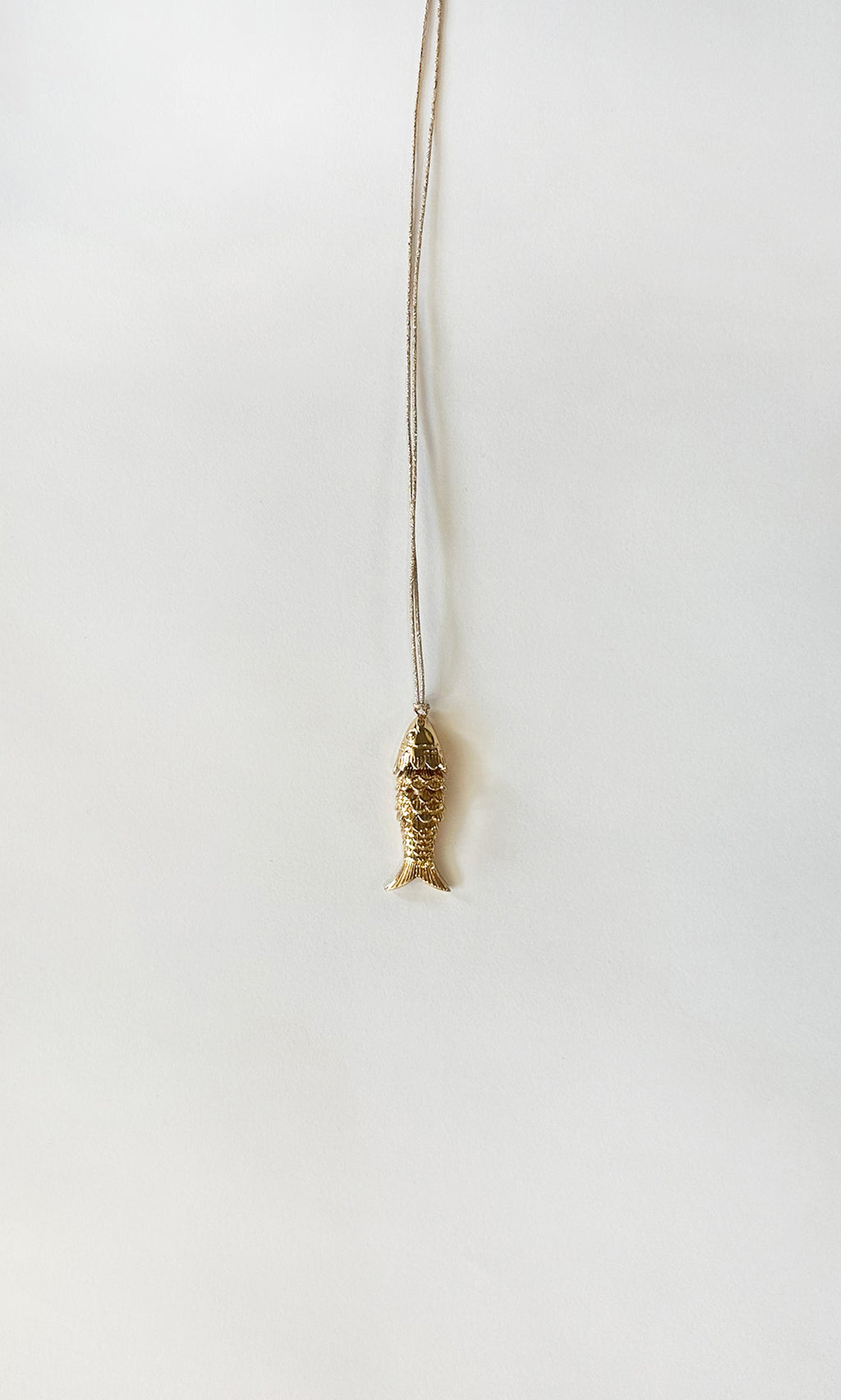 Plümo  Celine Necklace: Gold-plated fish pendant on an adjustable chain, ideal for layering; shown on a white background.