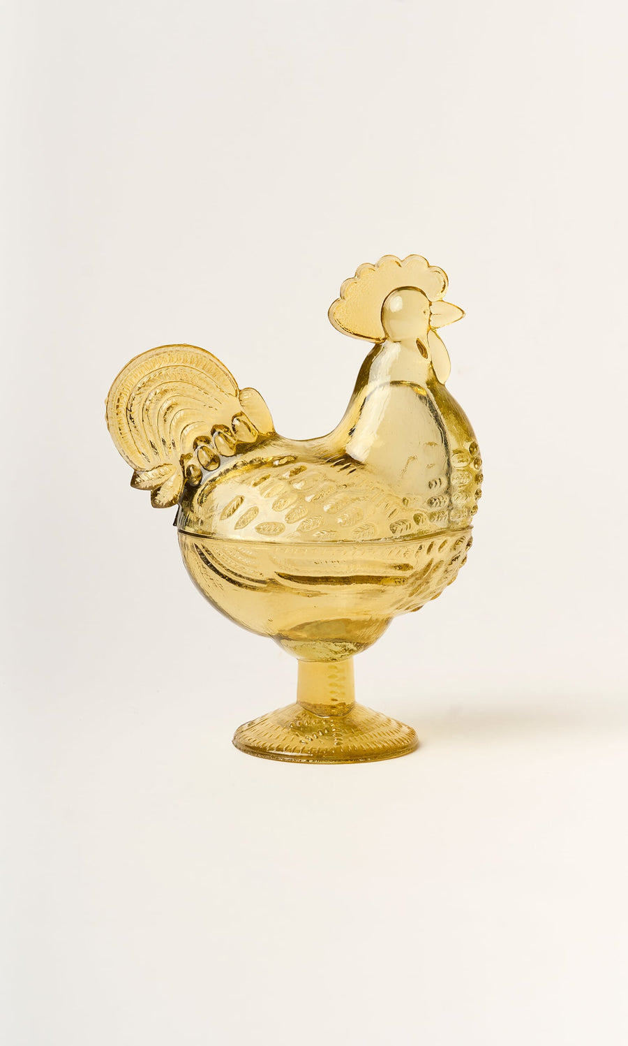 Plümo- The Glass Hen Bowl is a yellow lidded dish, ideal for decor or storage, shown on a white background.