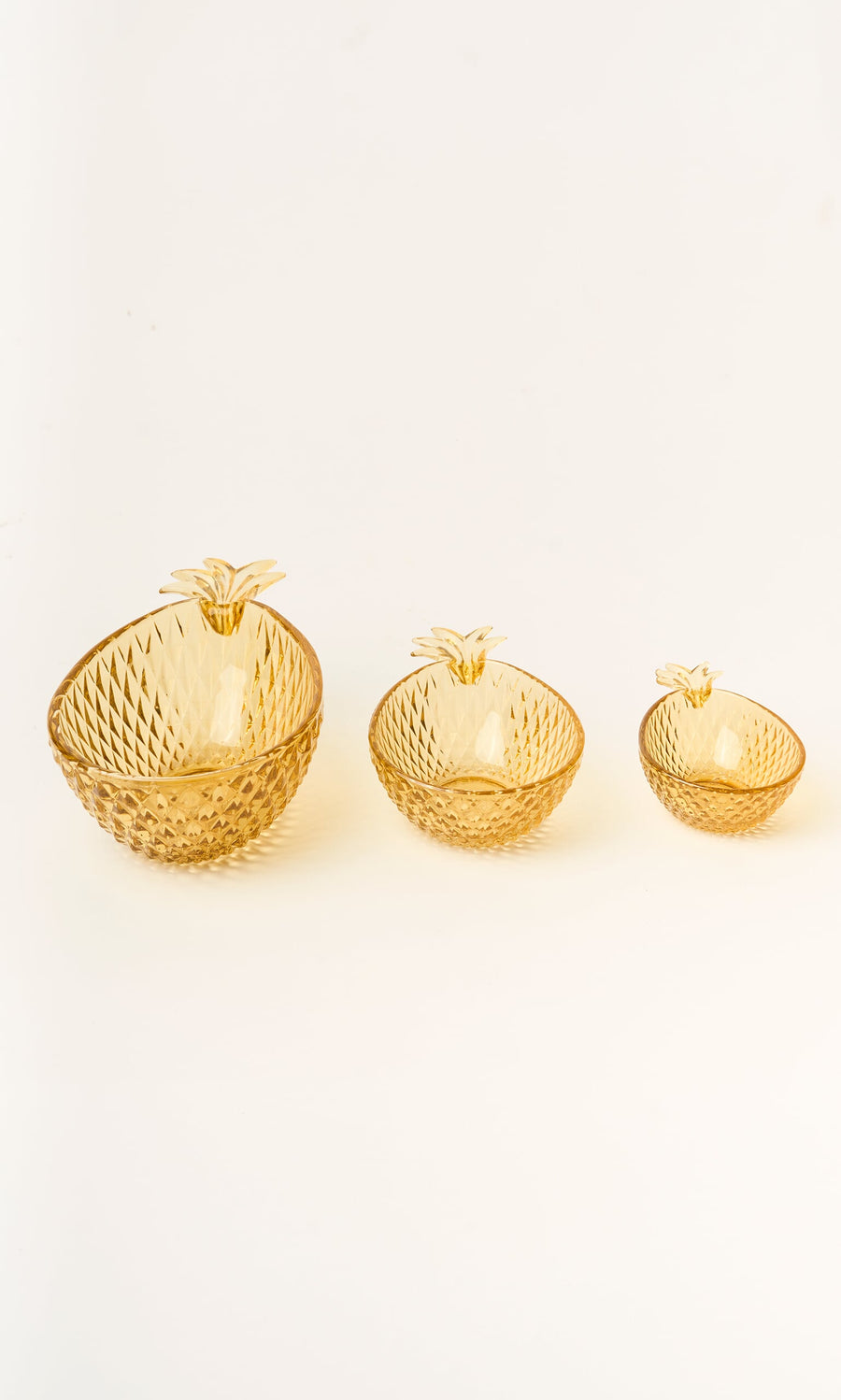 Plümo- Set of 3 Glass Pineapple Bowls in amber yellow, arranged by size from left to right.