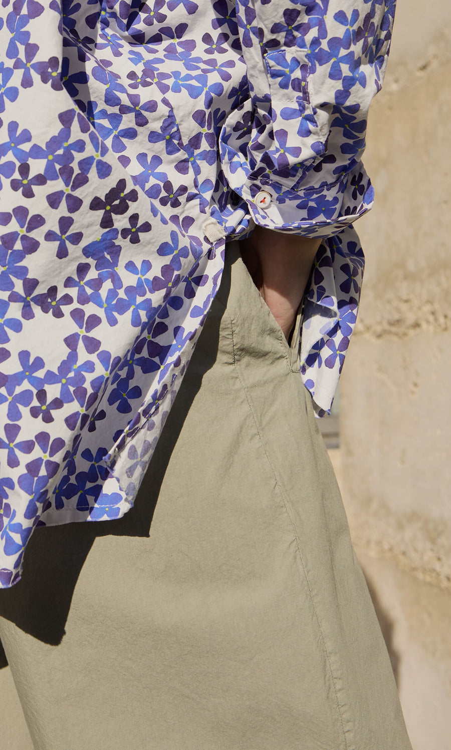Plümo- Person wearing a floral shirt and Khaki Poplin Pants, standing outdoors.