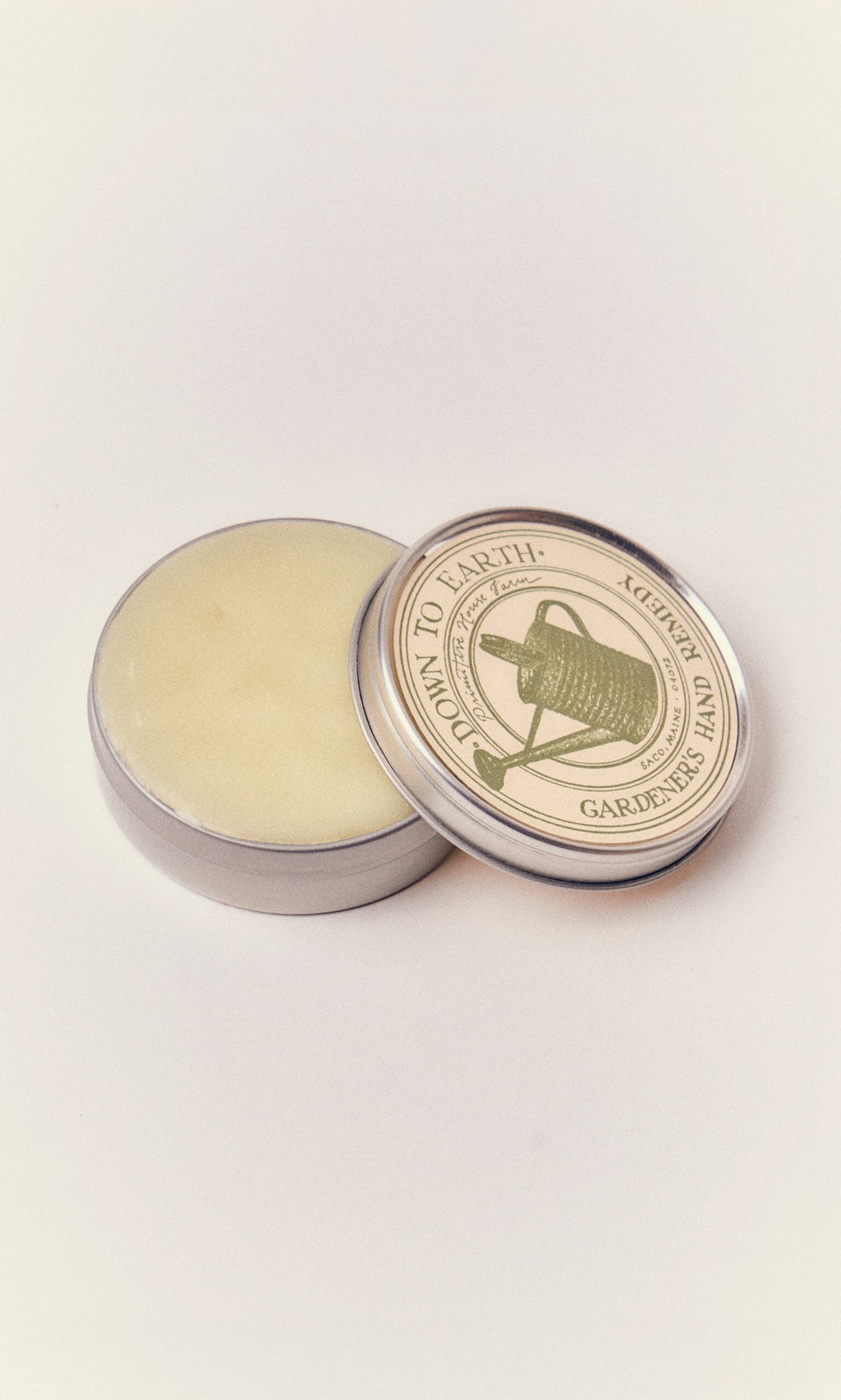 Plümo- Gardener's Hand Remedy: a round tin of nourishing hand balm, handcrafted in Maine with a gardening-themed label.
