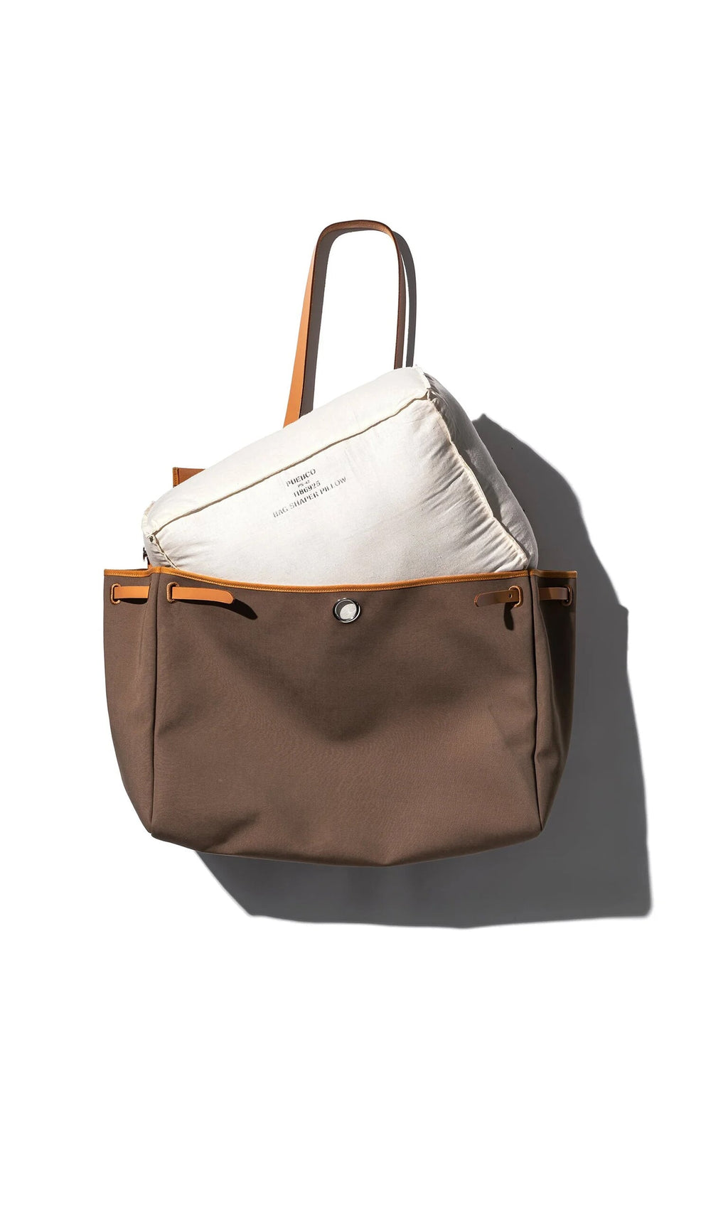 Plümo- A Handbag Shaper Pillow - Rectangle is held inside a brown tote bag with tan handles against a white background.