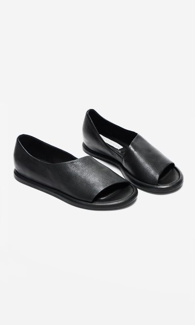 Plümo- Hawke Sandals: artisan-made black leather open-toe flats with a crisscross design on a white background.