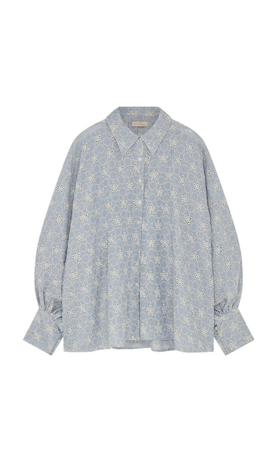 Plümo- The Hortence Blouse is a light blue broderie anglaise shirt with balloon sleeves, collar, and button closures.