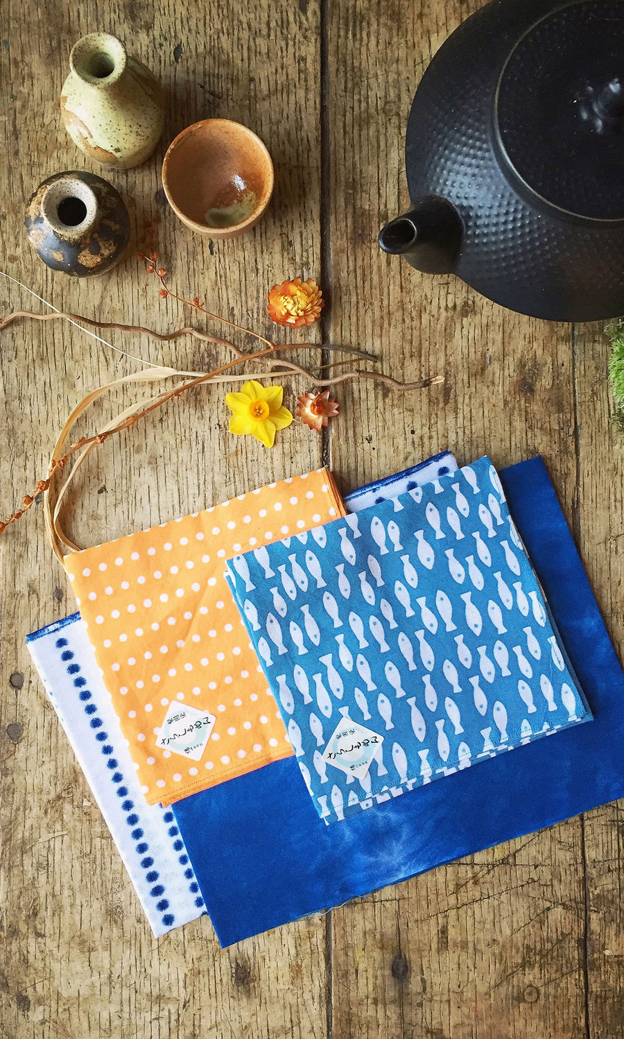 Plümo  Japanese Handkerchief - Fish displayed with ceramic bowls, a teapot, and flowers on a rustic table.