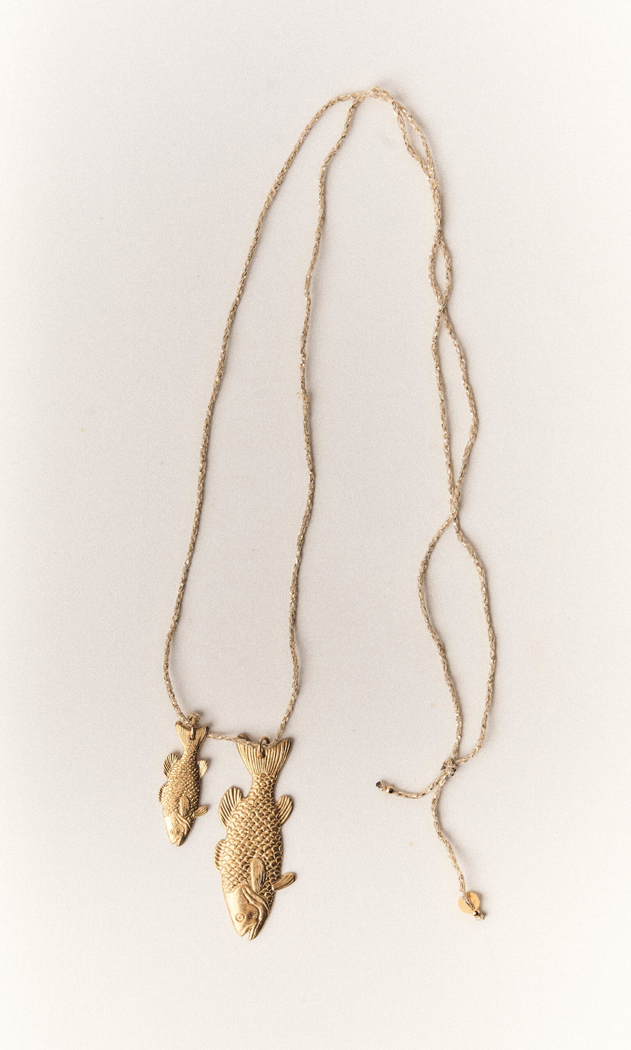 Plümo- Kala Necklace with two gold-plated fish pendants—one large, one small—on a delicate adjustable chain.