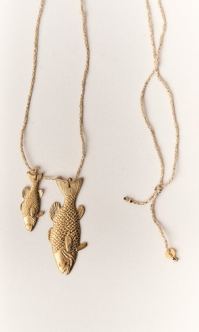 Plümo- The Kala Necklace features two gold-plated fish pendants on a textured, adjustable gold-toned chain.