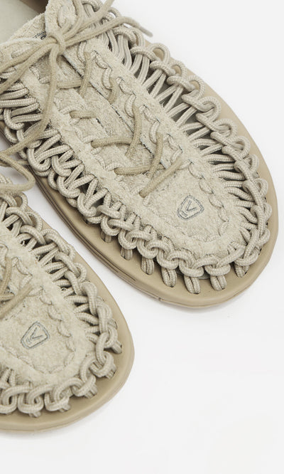 Plümo- Close-up of Keen Sandals - Pebble with thick looped cords and textured beige uppers on a white background.