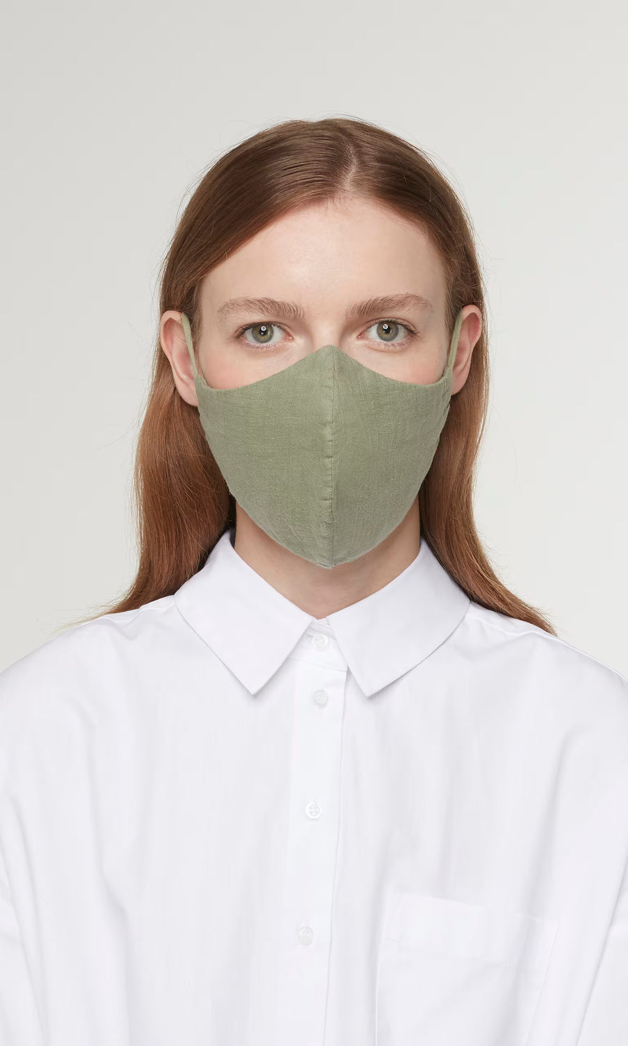 Plümo  Person with long brown hair in a white collared shirt, wearing the Organic Linen Mask - Leaf, facing forward.