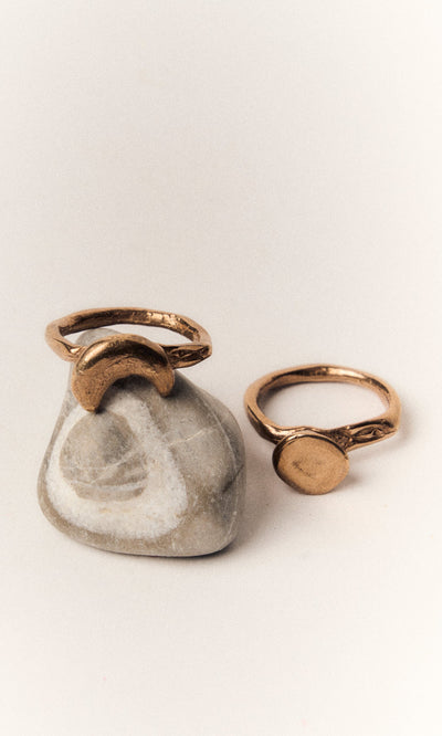 Plümo- The Moon Circle Stacking Ring is shown stacked on a smooth stone with a white swirl pattern.