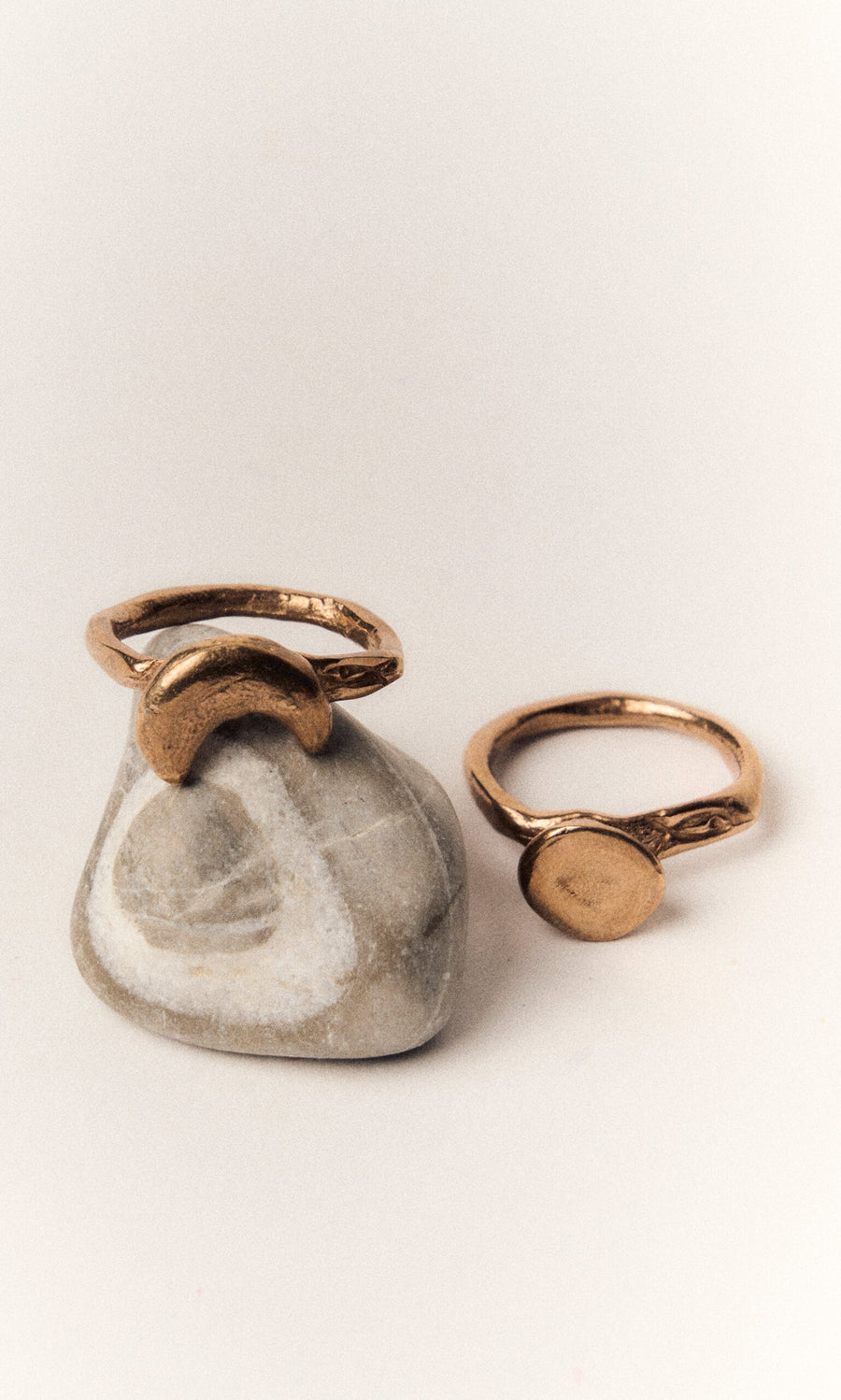 Plümo- The Moon Circle Stacking Ring is shown stacked on a smooth stone with a white swirl pattern.