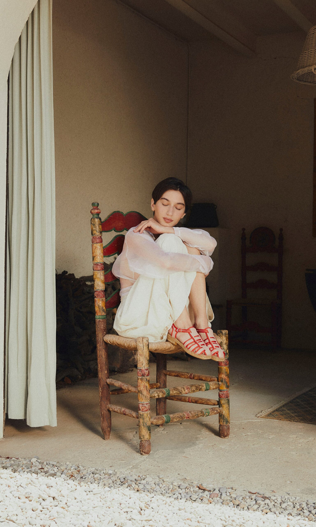 Plümo- A person sits indoors, eyes closed, hugging knees, wearing light clothes and Cordoba Espadrilles.