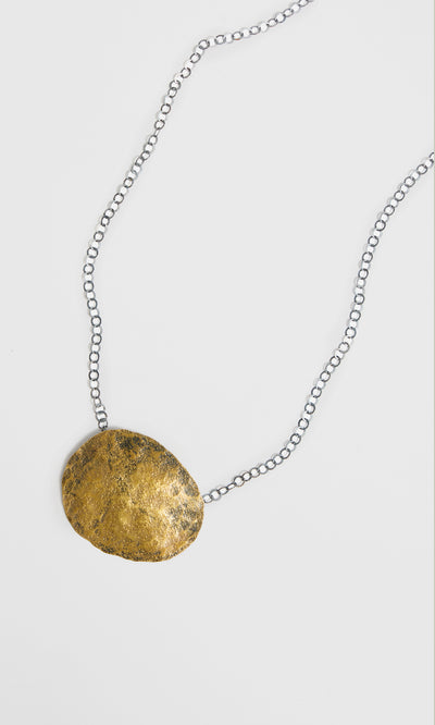 Plümo  Cressa Necklace: Artisan silver chain with a bold, textured gold pendant crafted from recycled materials.
