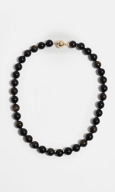 Plümo  Olena Necklace—golden obsidian beads with 18kt gold-plated clasp, styled in a circle on white background.