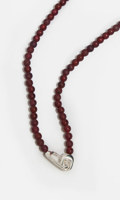 Plümo  Rowena Necklace: red jasper beads, sterling silver safety pin clasp, shown on a white background.