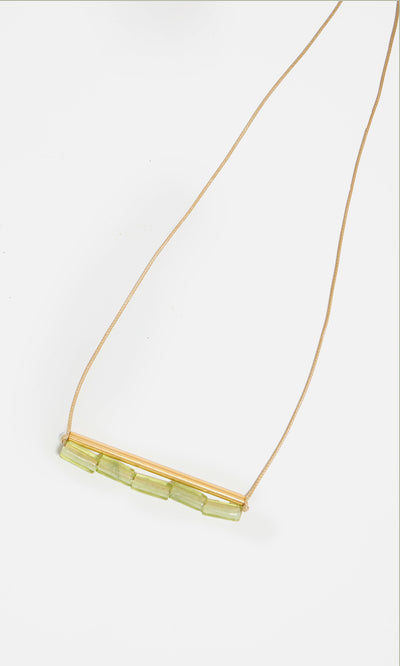 Plümo  The Lydia Necklace: a thin tan adjustable chain with a gold bar and five light green beads—elegant and stylish.