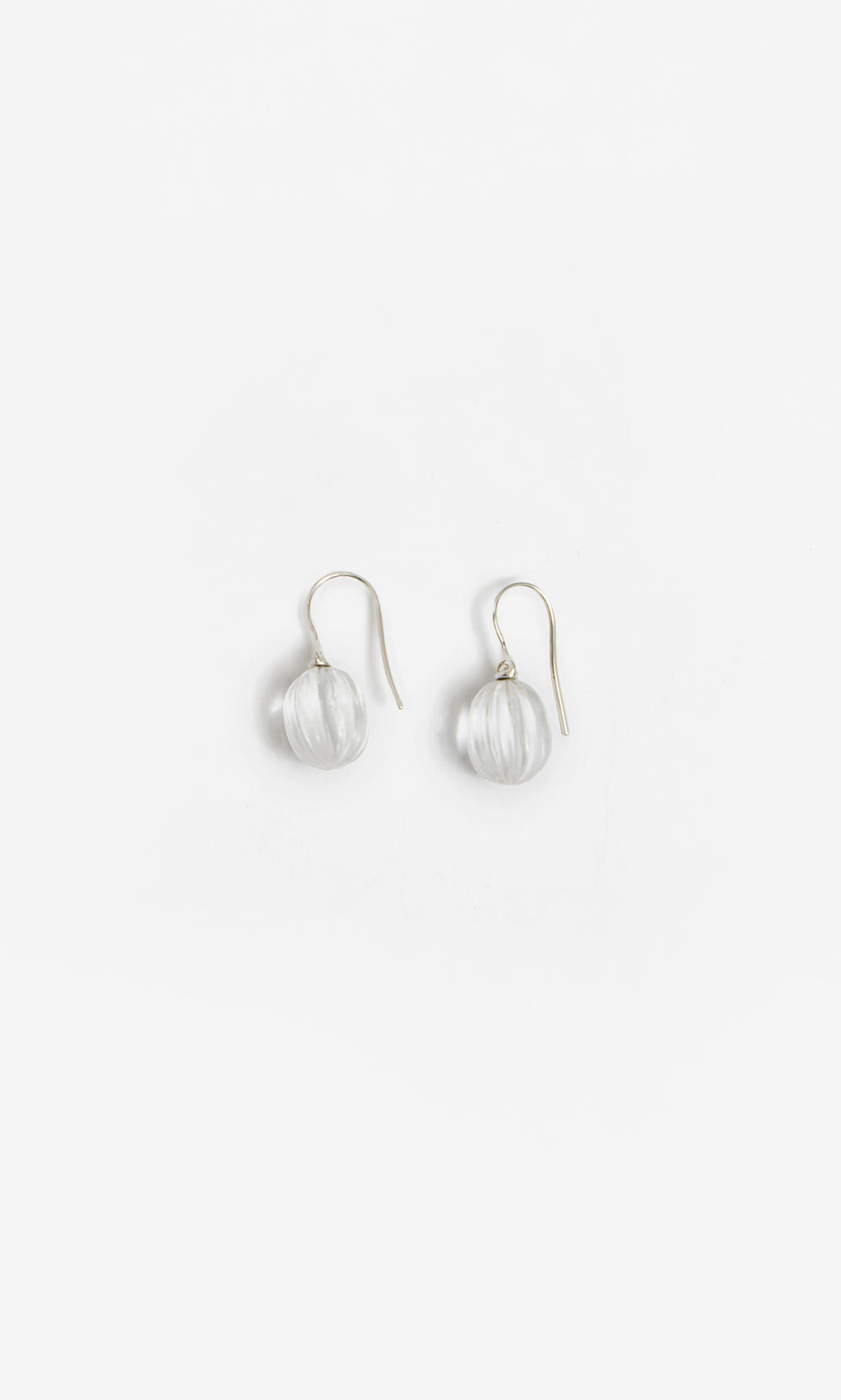 Plümo  Tamsin Earrings: Handcrafted crystal quartz with clear glass beads and silver hooks on a white background.