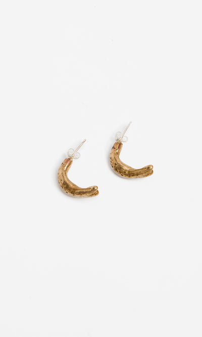 Plümo  Leaping Fish Hoops: small gold crescent-shaped earrings on white, inspired by ancient bronze fish earrings.