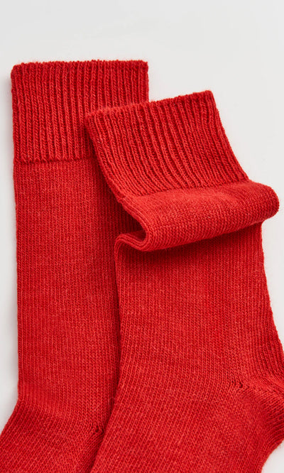 Plümo  Two Postbox Red Alpaca Socks with ribbed cuffs, one rolled down to show British craftsmanship.