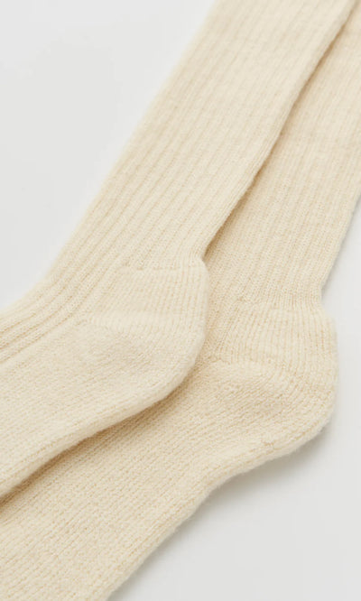 Plümo  Two Clotted Cream Knee Socks are laid flat, one slightly overlapping the other, on a white surface.