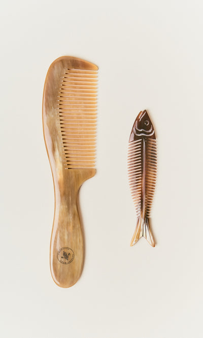 Plümo  Two Horn Combs: a wide-toothed comb for detangling and a fish skeleton design, both shown on a white background.