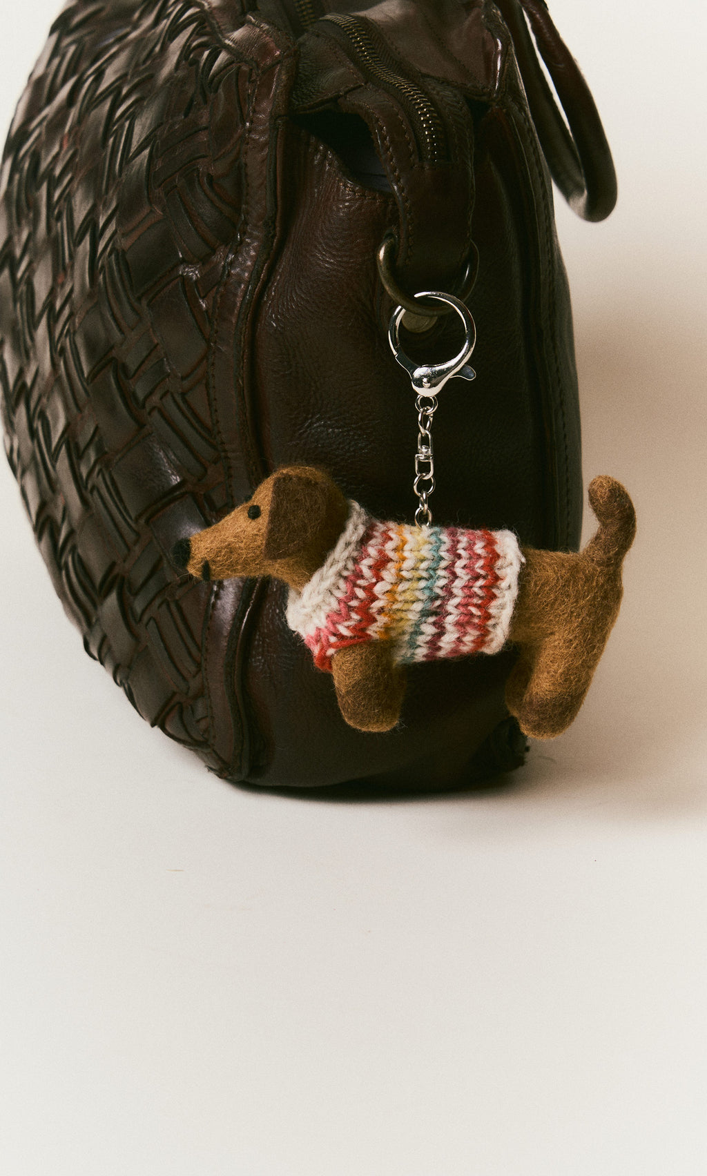 Plümo  Brown woven handbag with a Sausage Dog Keyring—hand-felted wool dachshund in colorful knit sweater on the handle.