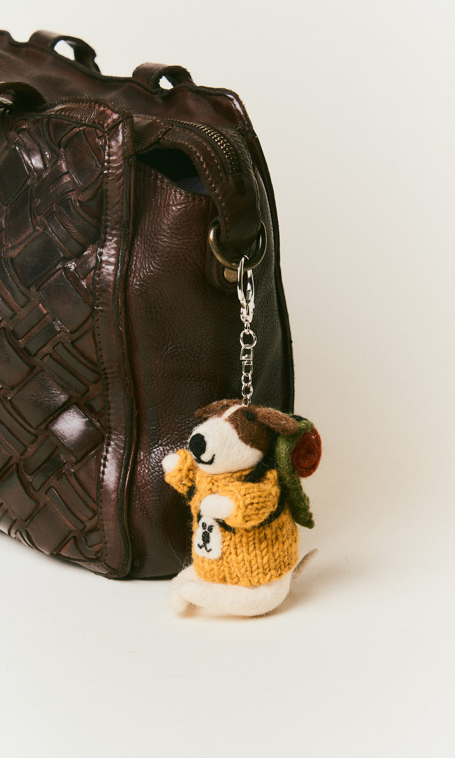 Plümo  A brown bag with a Rambling Roger Keyring—Fairtrade, hand-felted wool animal in yellow sweater and backpack attached.