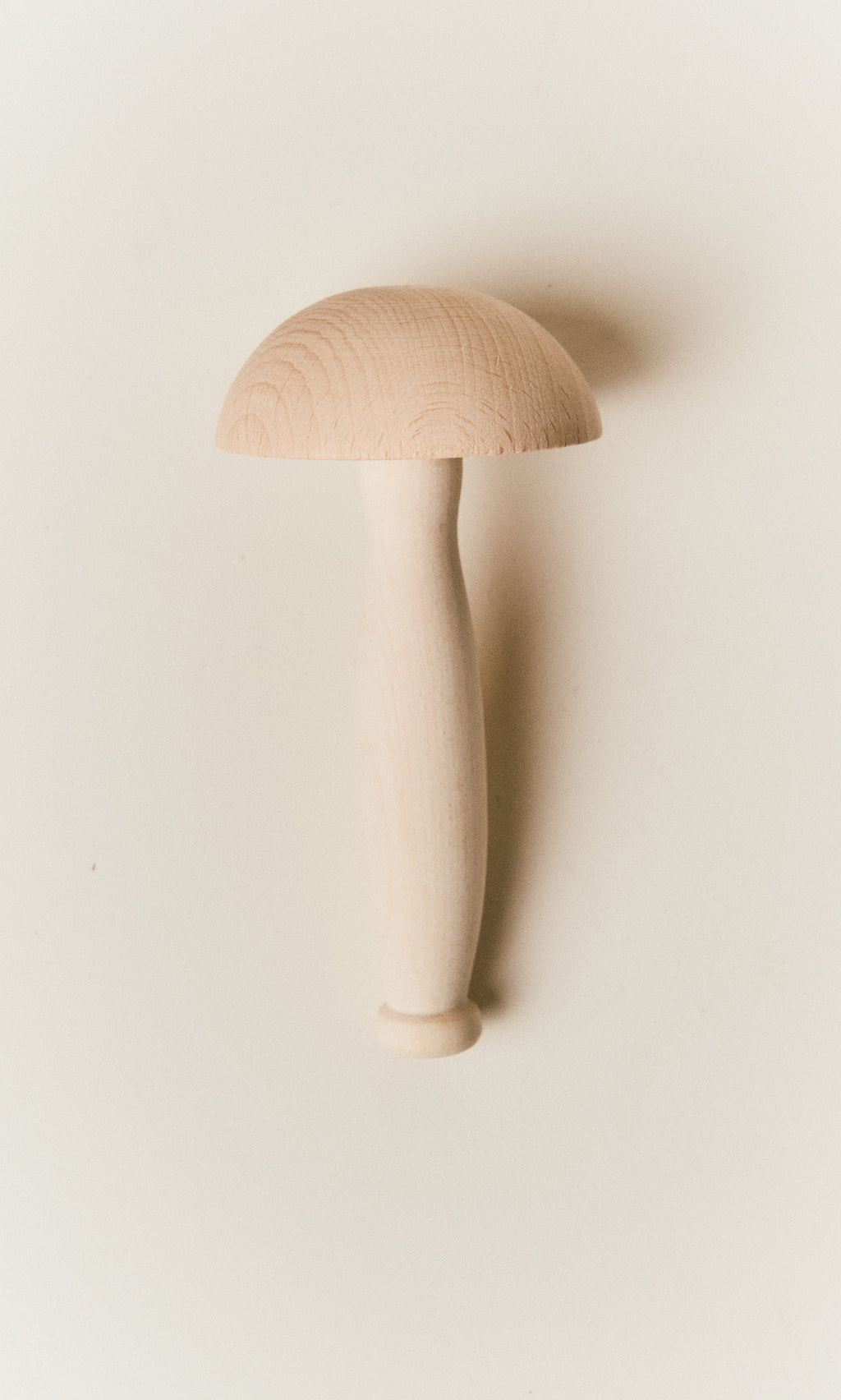 Plümo  A smooth, light-colored wooden darning mushroom.