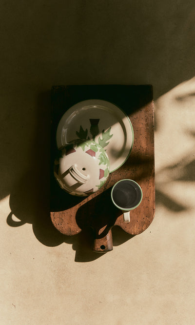 Plümo  The Thistle Cheese Dome, plate, bowl, and cup rest on a tray in sunlight, casting soft, elegant shadows.