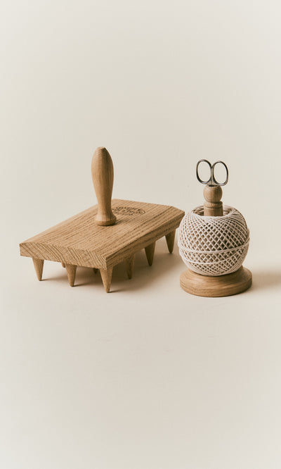 Plümo  Oak String Tidy and wooden meat tenderizer with stainless scissors on a neutral background.