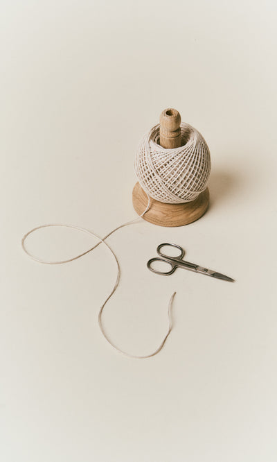 Plümo  Oak String Tidy with white twine and stainless steel scissors on a white surface.