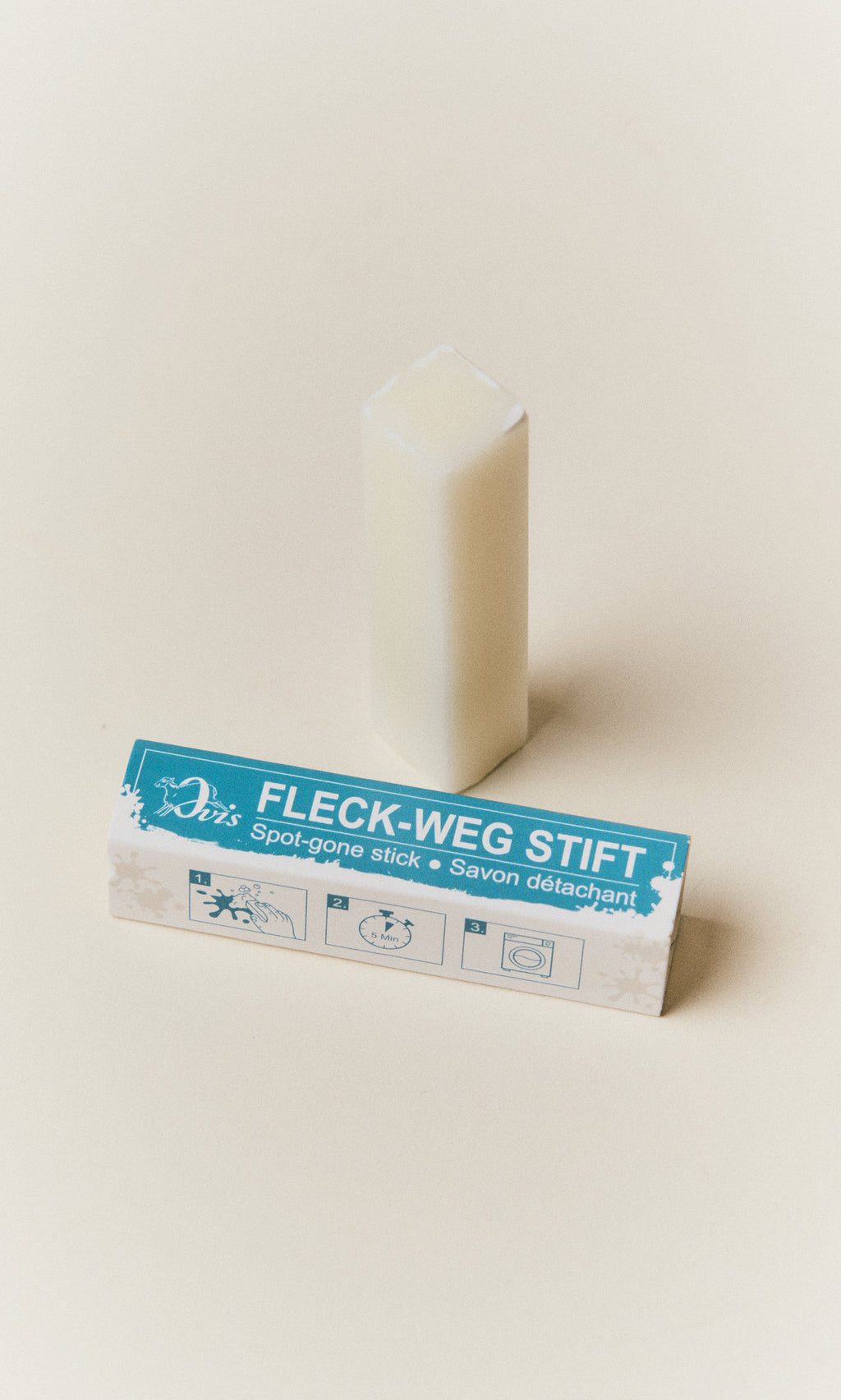 Plümo  A white rectangular Stain Remover Stick next to its blue and white box showing three instructional icons.
