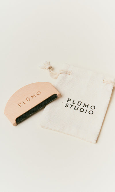 Plümo  A pink Wool Comb by PLÜMO rests with a PLÜMO STUDIO bag on a white surface.