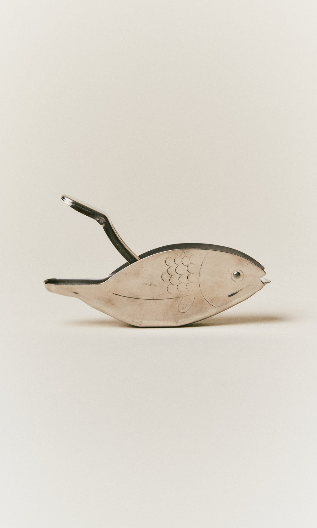 Plümo  A silver-toned metal Fish Lemon Squeezer shaped like a fish with an open handle.