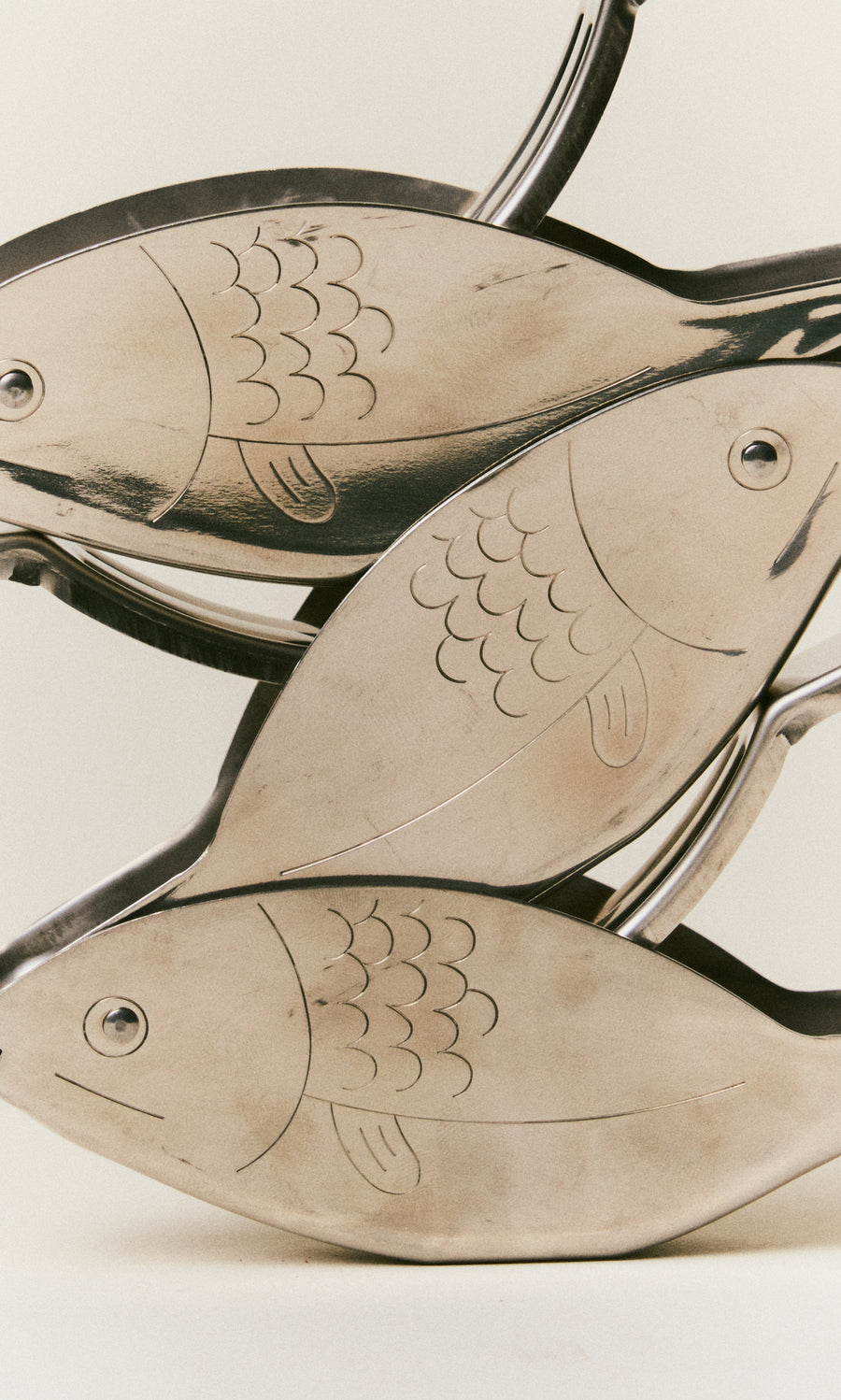 Plümo  Three metal Fish Lemon Squeezers shaped like fish stacked vertically.