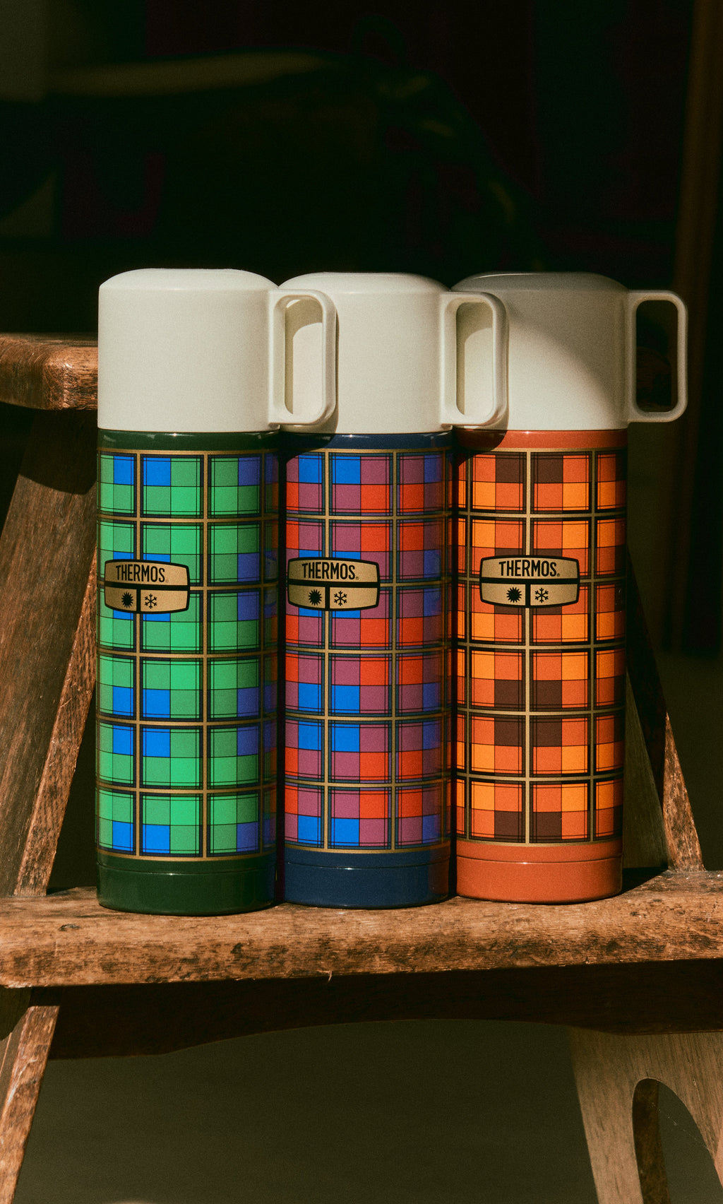 Plümo  Three Tartan Flask - Orange stainless steel flasks in colorful tartan patterns with cream-colored lids.