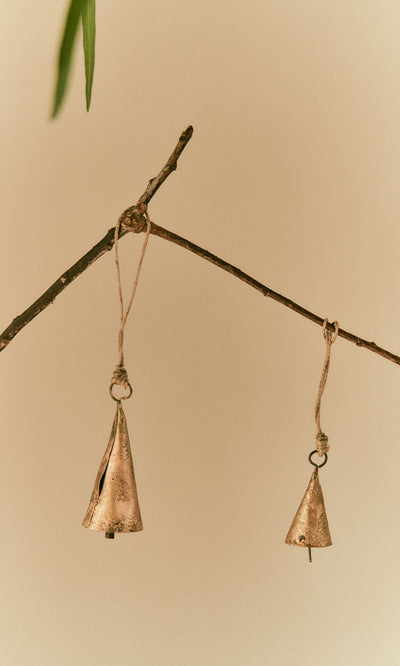 Plümo  Two Hanging Brass Bells - Small dangle from twine, chiming softly against a neutral beige background.