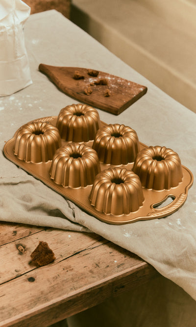 Plümo  Gold-colored cast aluminum Bundtlette Form with six individual fluted mini Bundt molds.