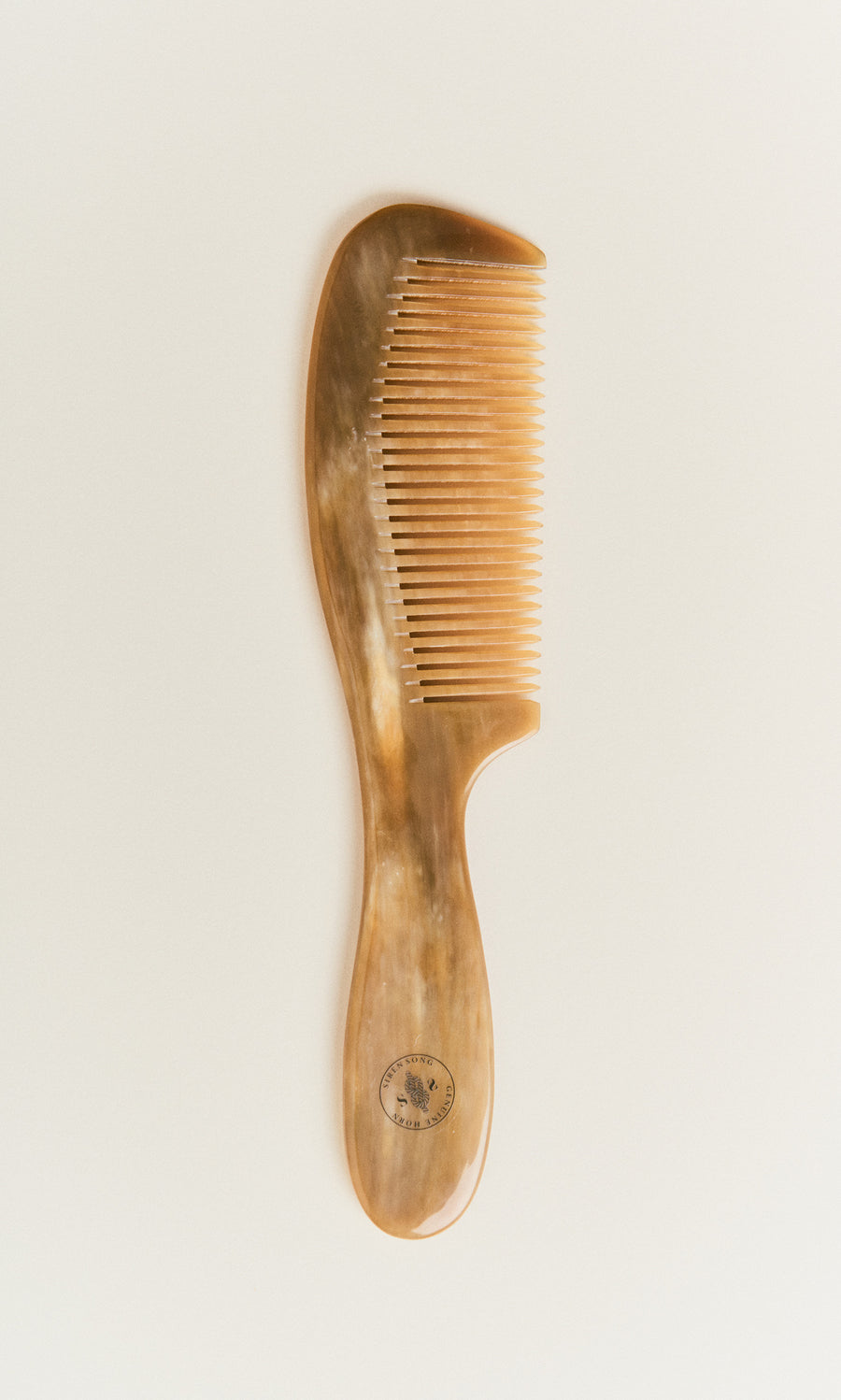 Plümo  A Horn Comb with fine teeth and a wide handle is displayed on a plain white background.