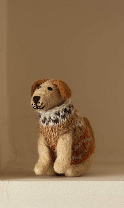 Plümo- Digby the Labrador, a small hand-felted wool dog in an orange, white, and brown sweater, sits on a light surface.