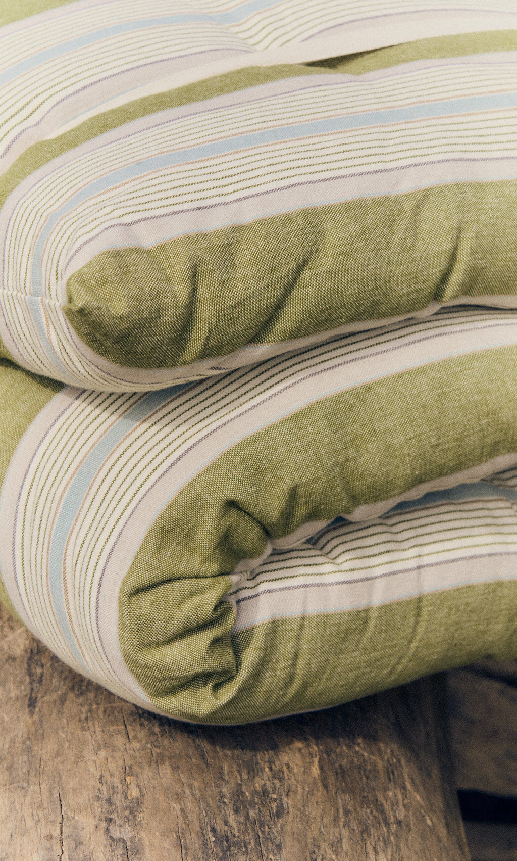 Plümo- Foldable Quilted Mattress - Green Stripe, neatly placed on a wooden surface.