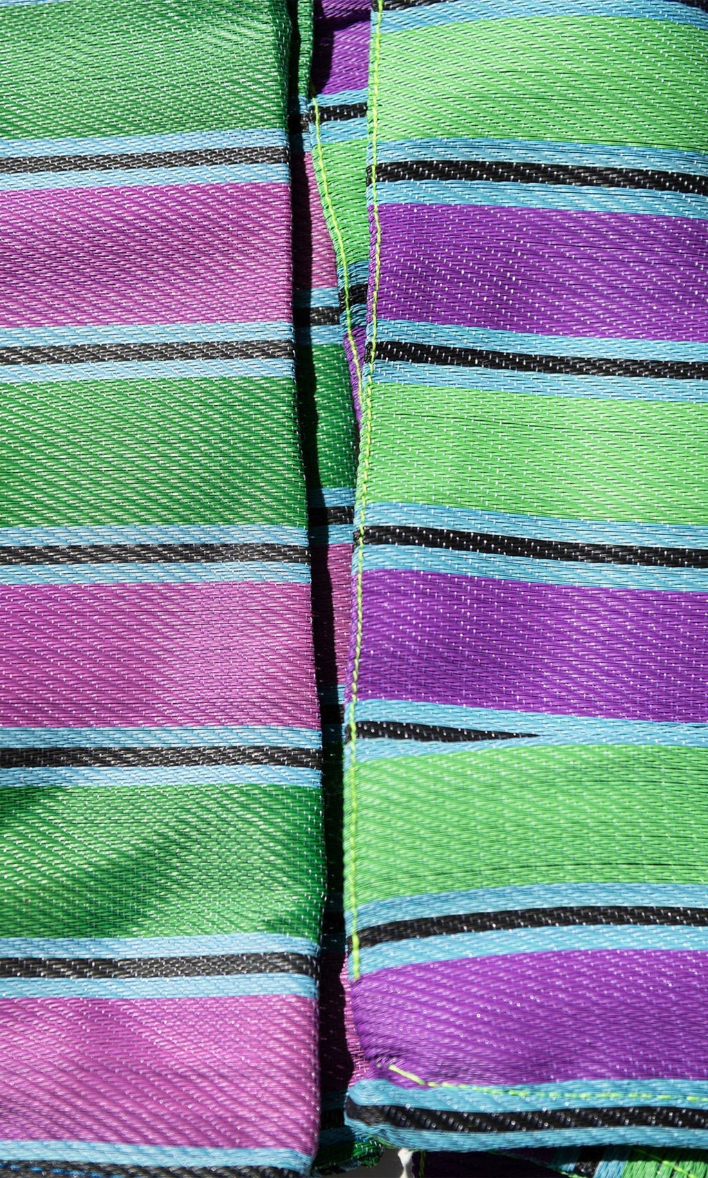 Plümo- Close-up of Recycled Stripe Shopper fabric with green, purple, blue, and black stripes plus visible stitching.