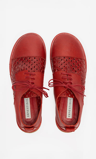 Plümo- Top view of Magui Brogues in red artisan leather with woven detailing and visible brand labels inside.