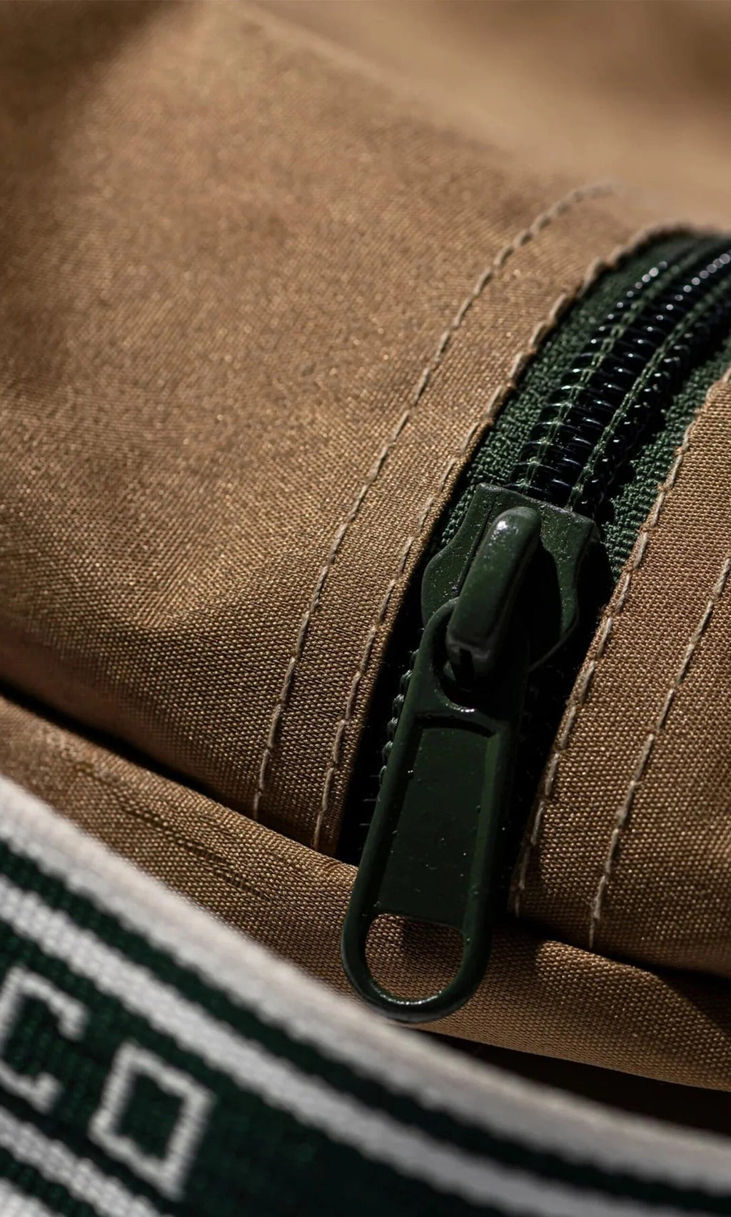 Plümo- Close-up of the Rubberised Shoe Case with green zipper, brown fabric, and white-green stripes—perfect for travel storage.