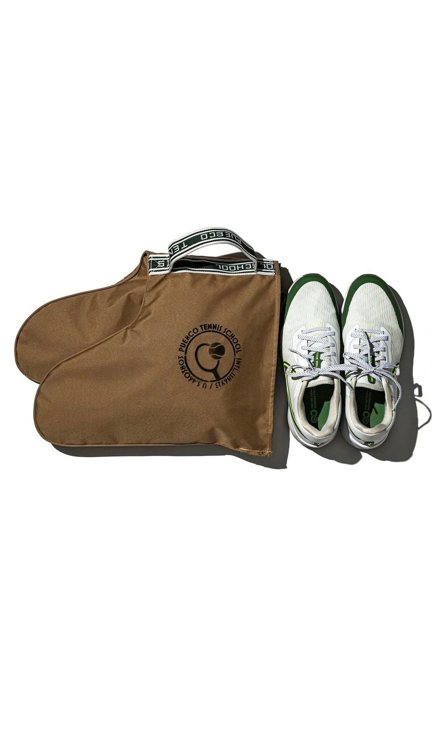 Plümo- White and green sneakers beside a Rubberised Shoe Case in brown with a circular logo, ideal for travel storage.