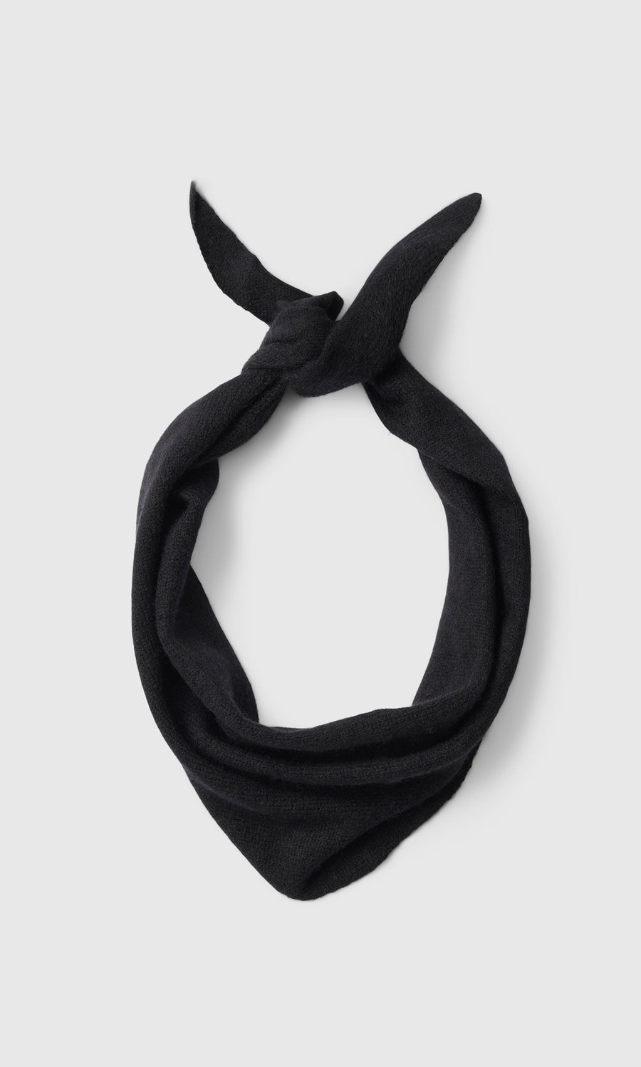 Plümo  A Black Cashmere Necktie, tied simply and inspired by Danish design, rests on a plain light gray background.
