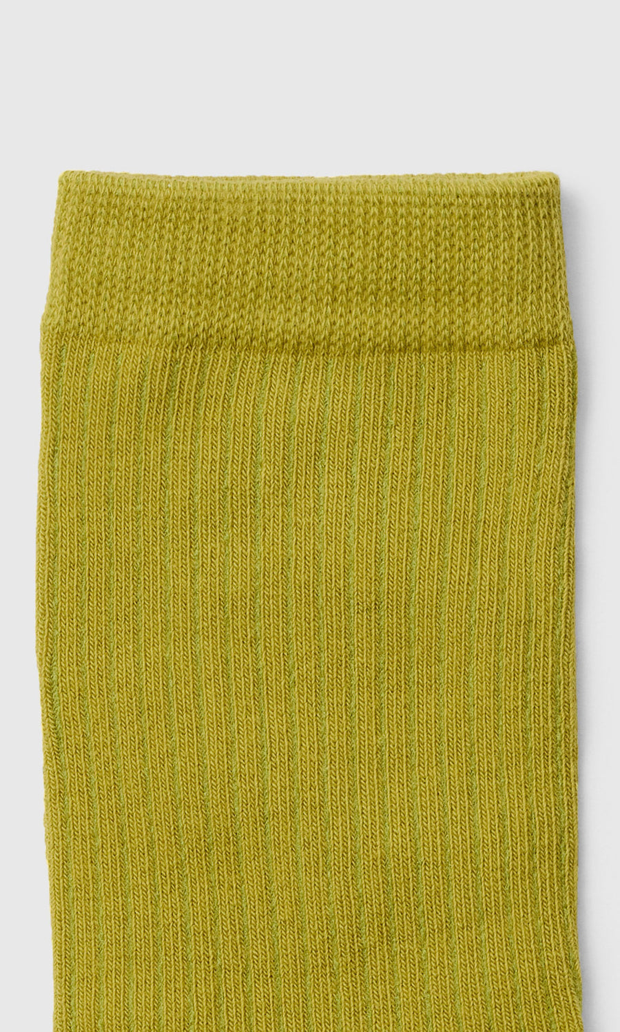 Plümo  Close-up of the top part of a rib-knit, bright green sock against a white background.