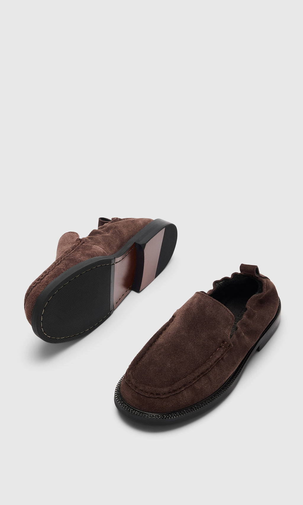 Plümo  Dobin Loafers in brown suede, black soles, cushioned insoles; one displays the distinctive sole design.